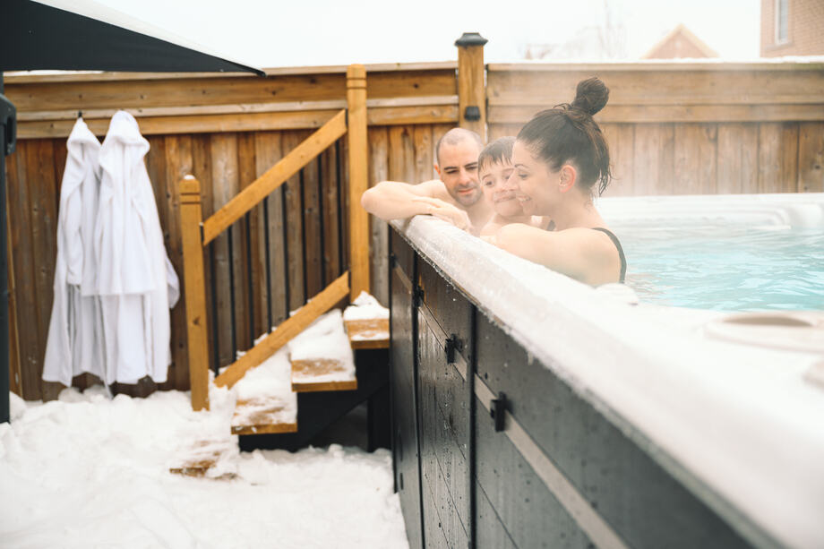 Une famille profite de son spa de nage en plein hiver. 