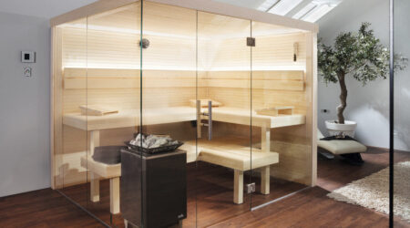 Un sauna avec de grandes surfaces vitrées est installé en intérieur.