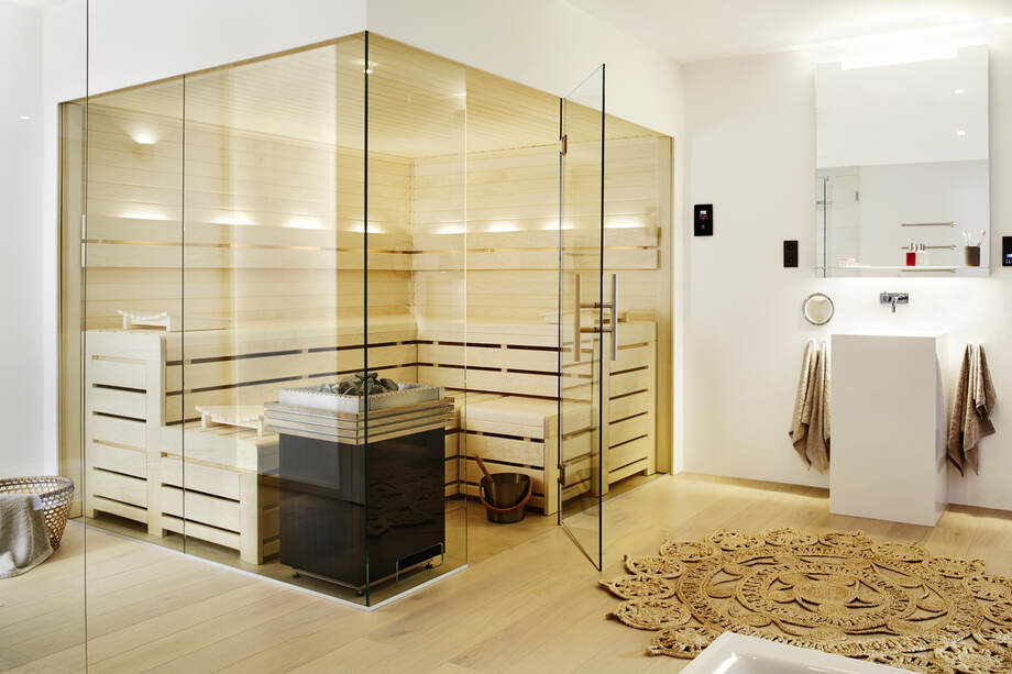 Un sauna traditionnel avec de grandes surfaces vitrées est installé dans une salle de bain. 