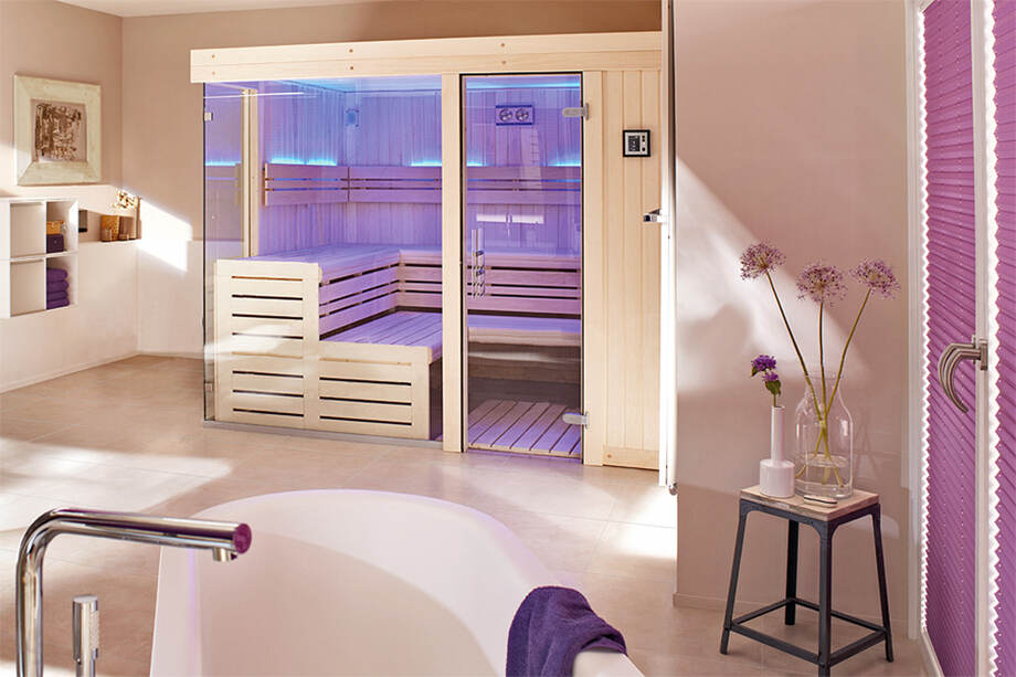 Un sauna traditionnel, doté d'une grande surface vitrée, est installé dans une salle de bain