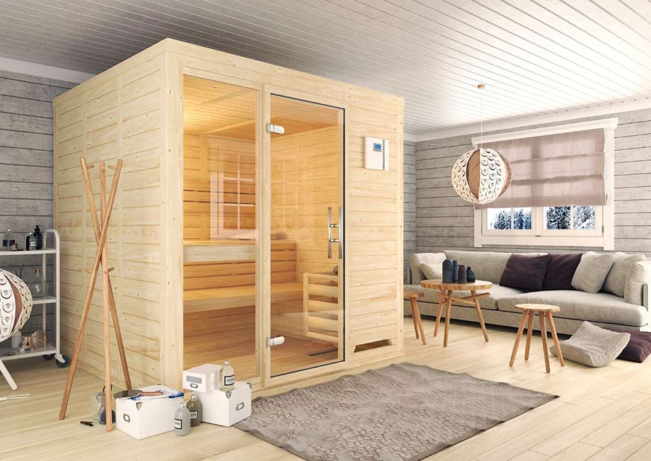 Un sauna en bois clair est installé dans une pièce cosy, près d'un canapé. 