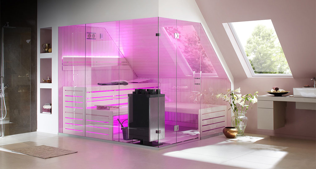 Sauna Lambris Design totalement vitré avec une lumière d'ambiance rose, dans une salle de bain.