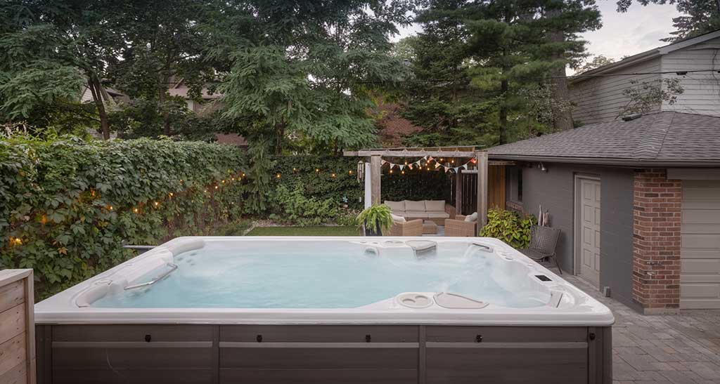 Spa de nage 14AX posé sur une terrasse en bois.