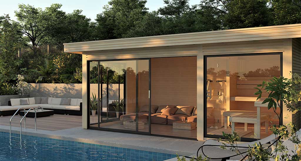 Pool House avec porte vitrée ouverte coin sauna et détente avec fauteuils à l'intérieur, piscine en premier plan et salon de jardin sur le côté