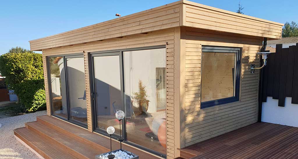 Pool House avec baies vitrées sur une terrasse en bois