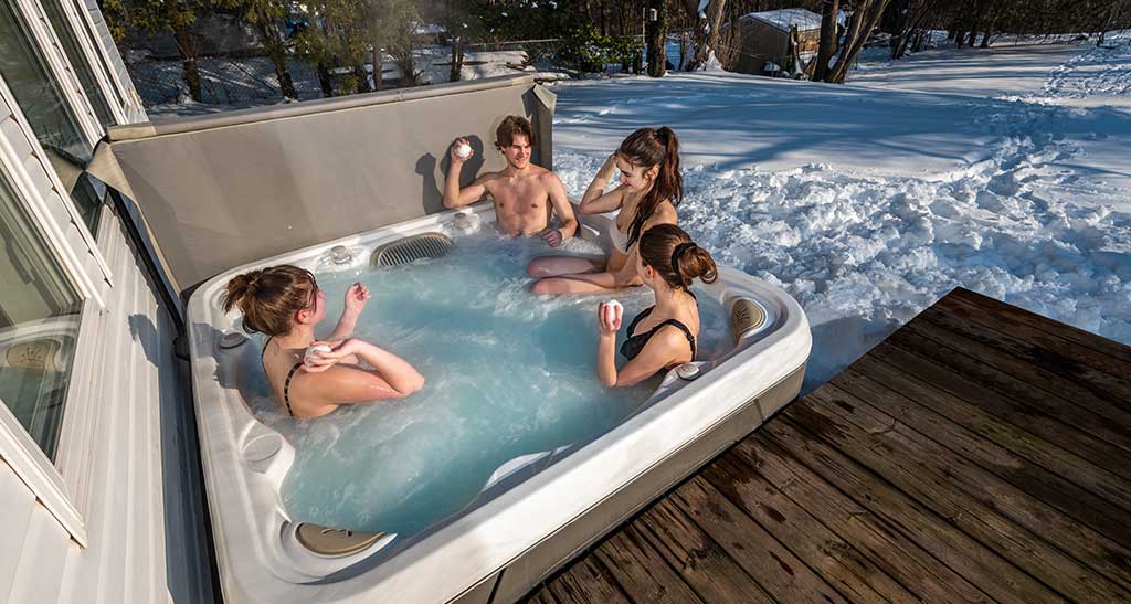 Des adolescents se baignent sous la neige dans le spa S66.