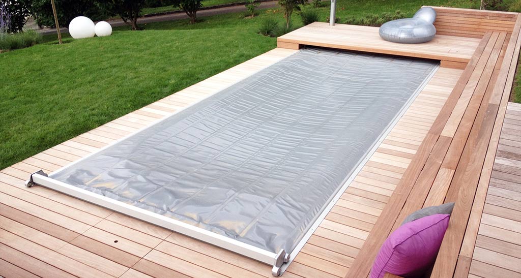 Couverture ISO+ pour spa de nage fermé sur spa de nage encastré dans une terrasse en bois dans un jardin