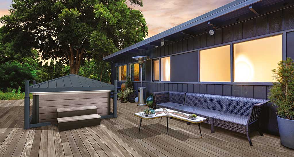 Abri Hydrocover pour spa fermé sur une terrasse aménagée avec un coin salon de jardin à l'arrière d'une maison illuminée