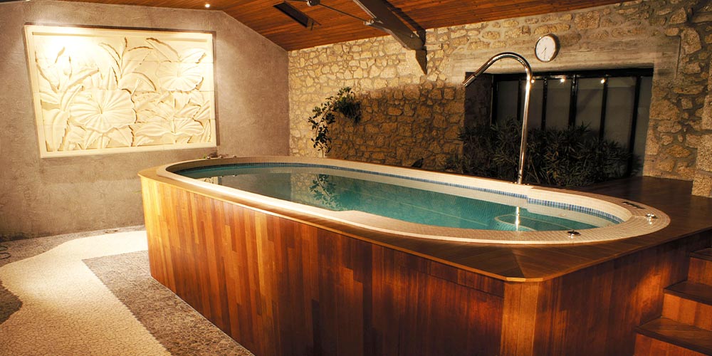 Spa de nage installé en intérieur avec un habillage en bois