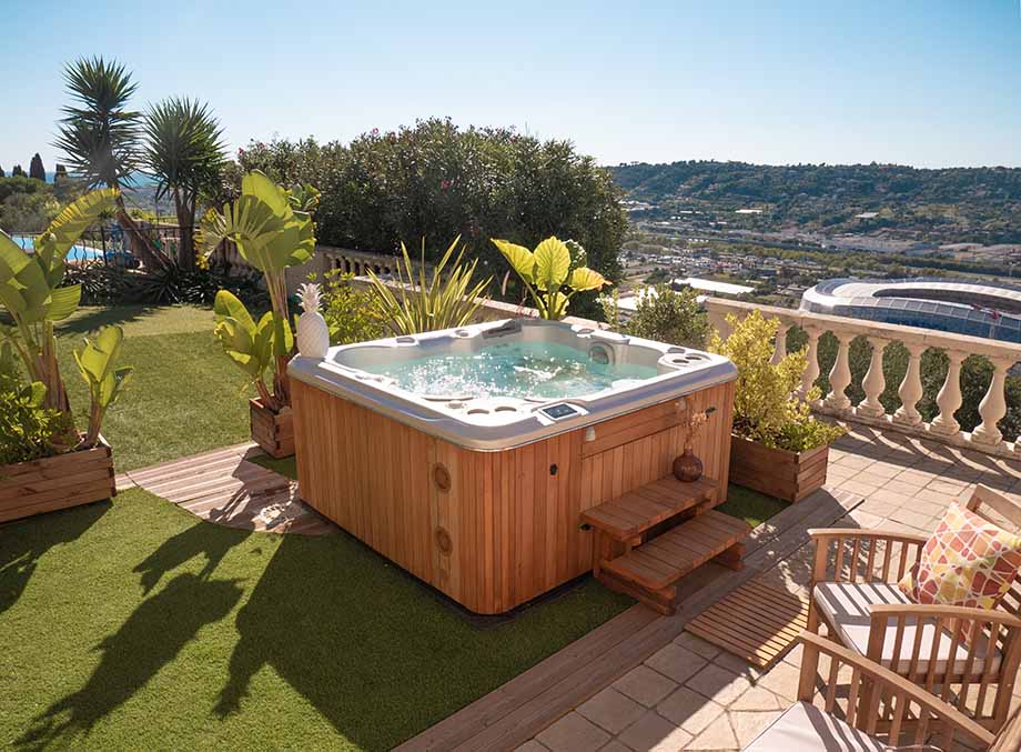 Un spa extérieur est installé dans un jardin et offre une magnifie vue sur le paysage environnant.