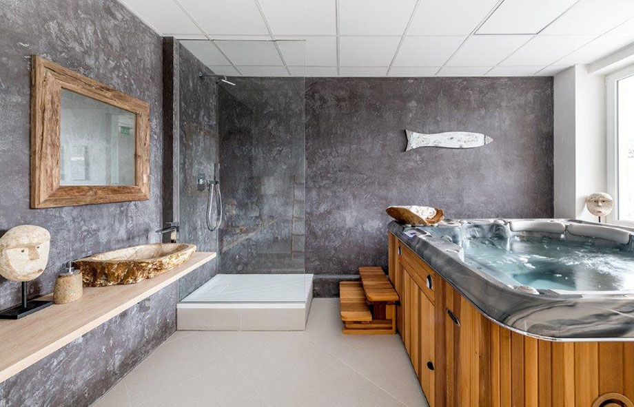 Un spa portable est installé dans une salle de bain soigneusement décorée. 
