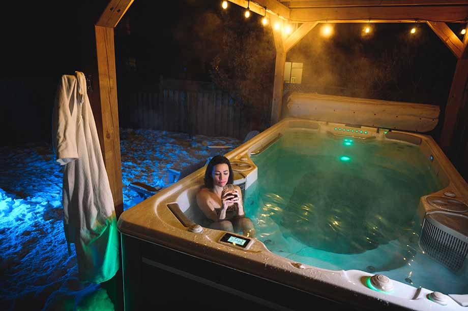 Une femme se détend la nuit dans un spa de nage  et profite des bienfaits de la chromothérapie. 
