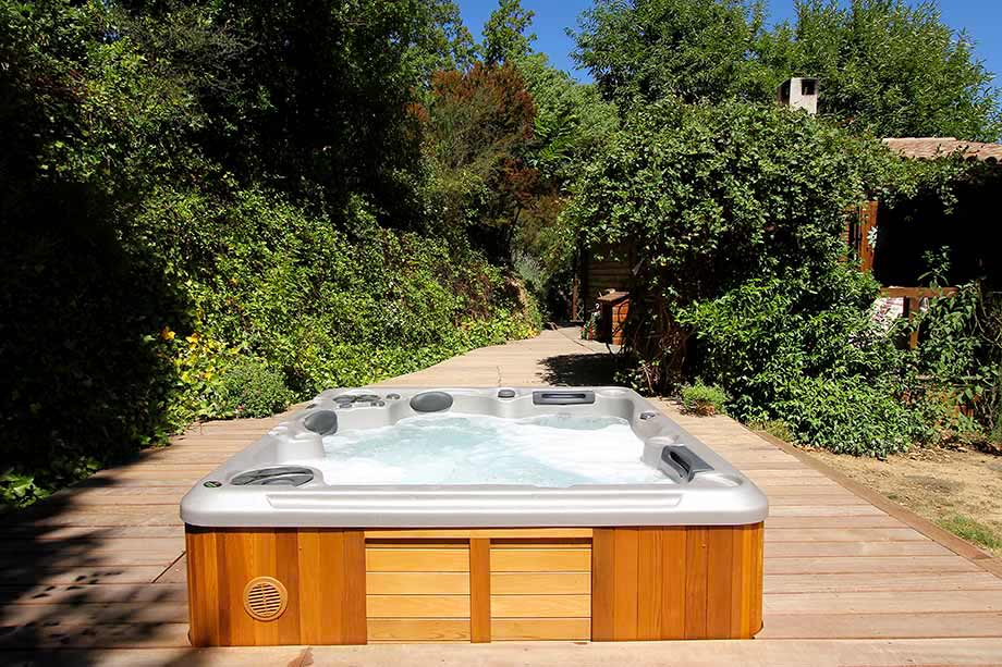 Un spa est encastré dans une terrasse en bois