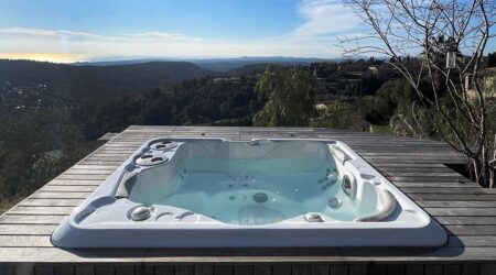 Un spa est installé en extérieur, face à une vue superbe. Il est encastré dans une terrasse en bois