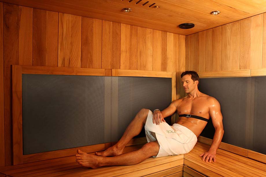 Un homme profite d'un bain de chaleur sèche dans un sauna infrarouge. 