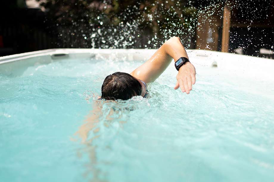 Un homme pratique la natation sportive dans un spa de nage. 