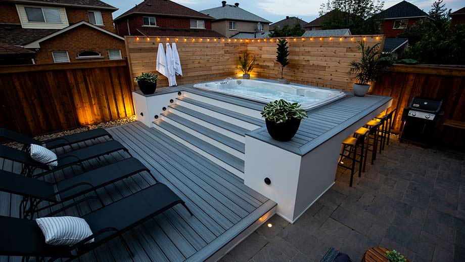 Un spa de nage est élégamment encastré dans une terrasse. Un escalier a été réalisé pour accéder au spa de nage. 