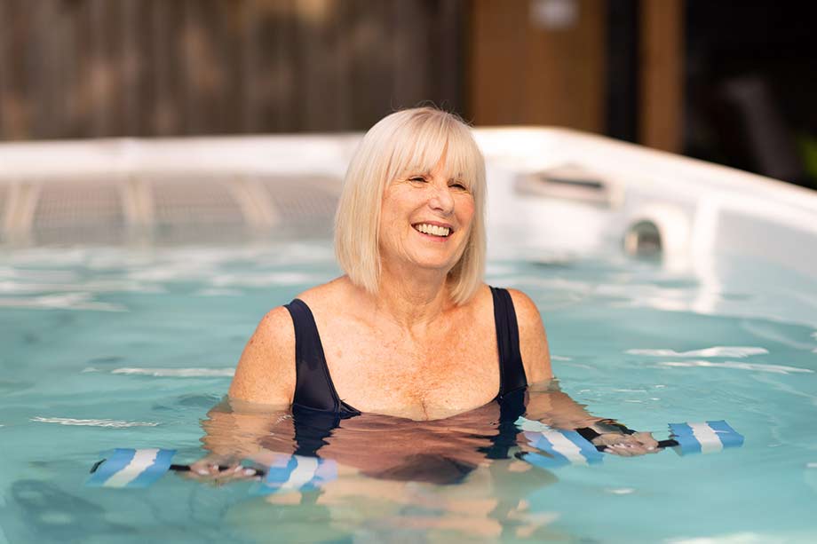 Une femme fait des exercices d'aquagym dans un spa de nage. 