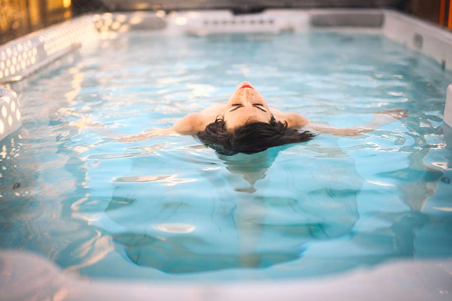Une femme fait des exercices dans un spa de nage. 