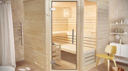 Combien coûte un sauna traditionnel? Sur cette photo, un sauna en bois clair est installé dans un e pièce.