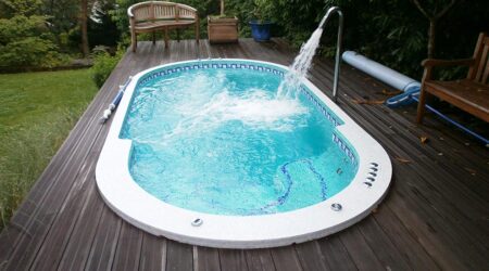 Quelle est la consommation d'eau d'un spa de nage ? un spa de nage recouvert de mosaïque est installé sur une terrasse en bois.