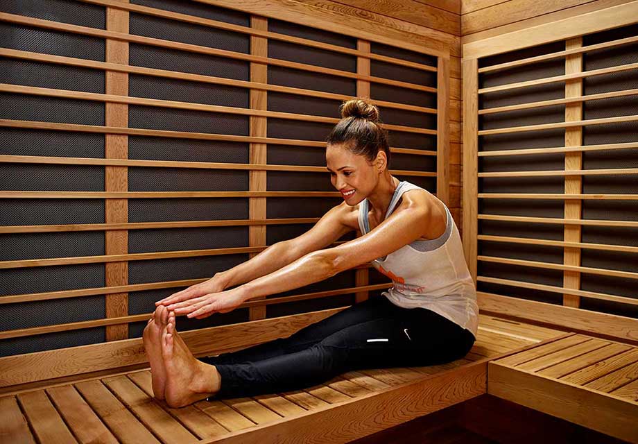 Une femme s'étire dans un sauna infrarouge. 