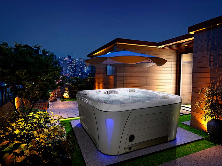 Un spa portable est installé en extérieur. Des éclairages extérieurs ont été installés tout autour du spa pour créer une atmosphère chaleureuse. 