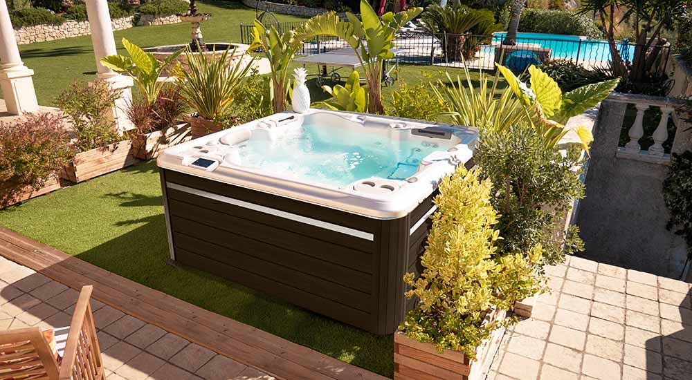 Un spa portable est installé dans un jardin. Pour bien l'entretenir, il est important d'utiliser des produits adaptés.