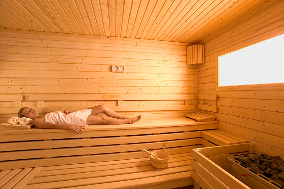 Une femme est allongée dans un sauna traditionnel. 