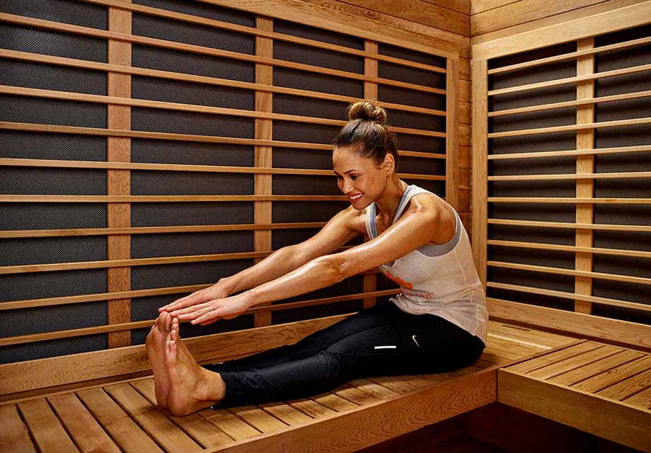 Combien coûte un sauna infrarouge ? Sur cette photo, une femme s'étire dans un sauna infrarouge. 