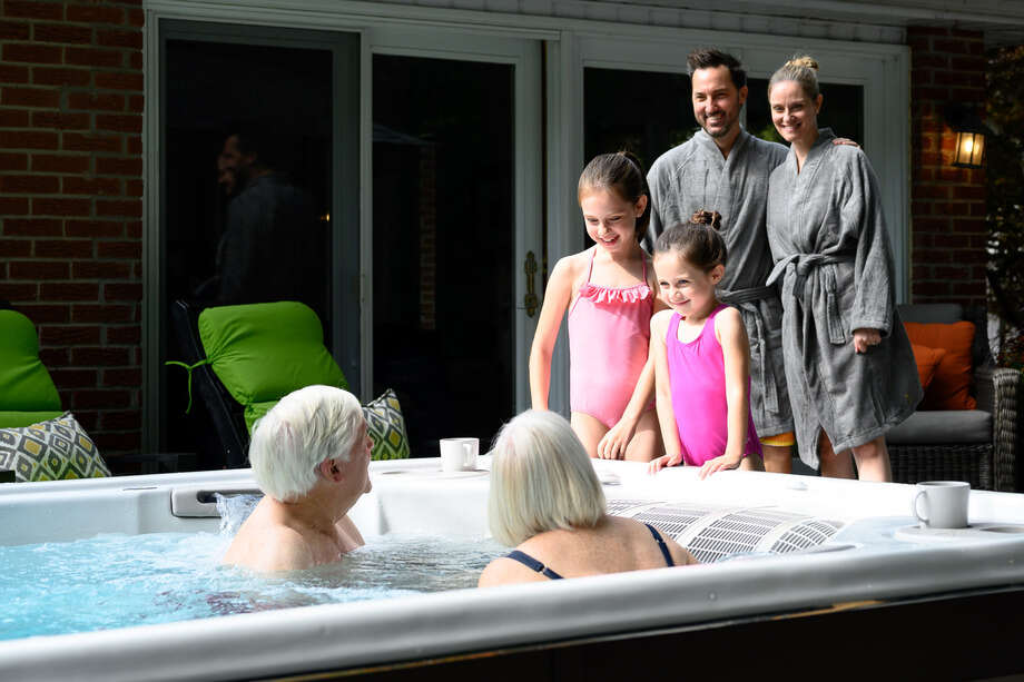 Les parents, les enfants et les petits-enfants sont réunis autour d'un spa de nage. 