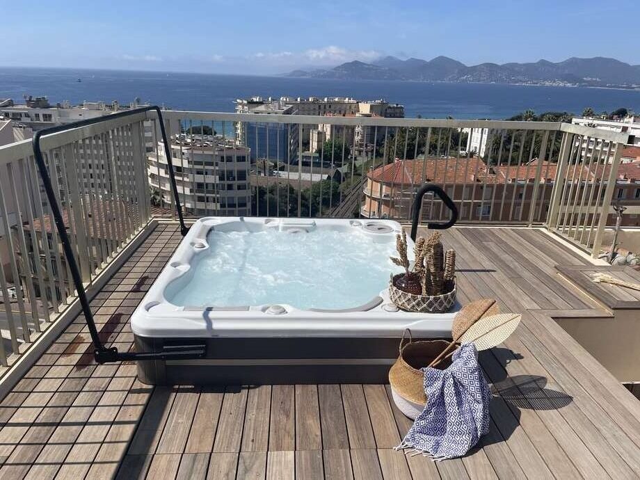 Un spa est installé sur la terrasse d'un immeuble et bénéficie d'une vue sur la mer. La livraison du spa a nécessité l'intervention d'une grue. 