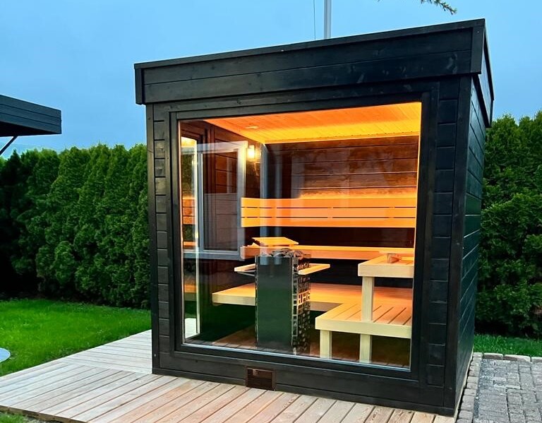 Un sauna extérieur est installé sur une terrasse, dans un jardin. 