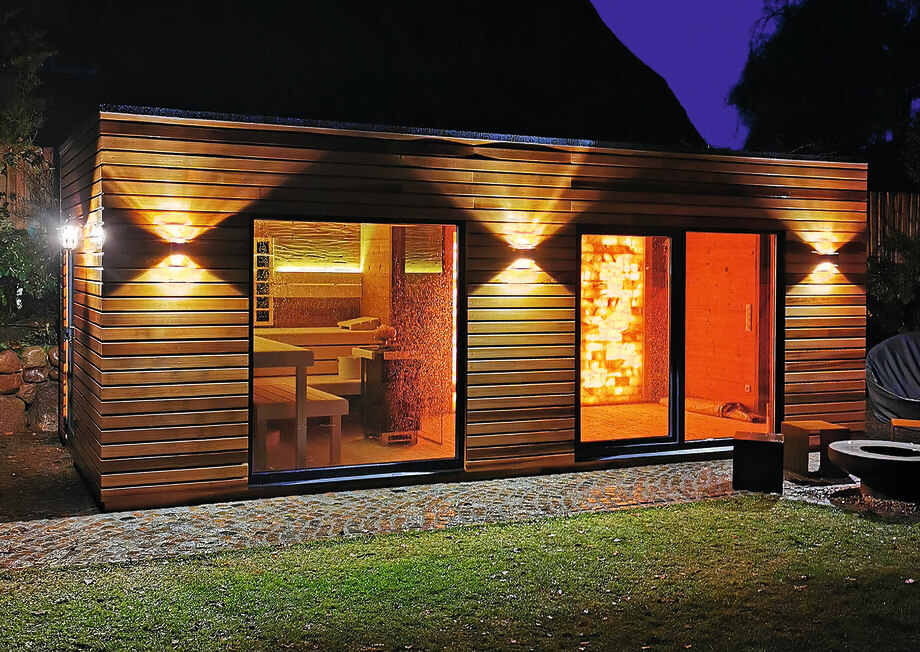 Un sauna extérieur est installé dans un jardin. 
