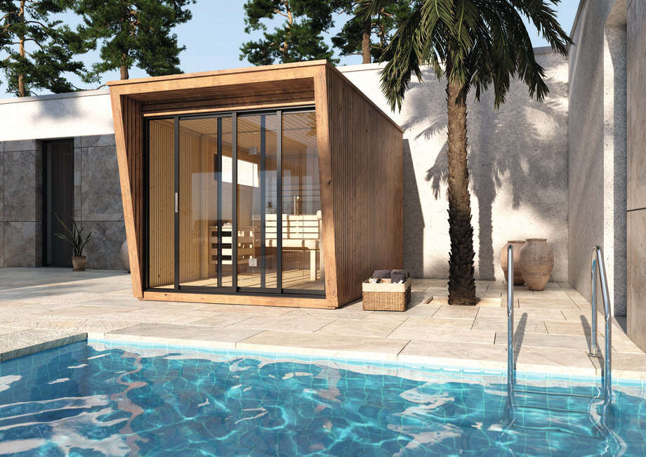 Un sauna design est installé en extérieur sur une terrasse, à proximité d'une piscine. 
