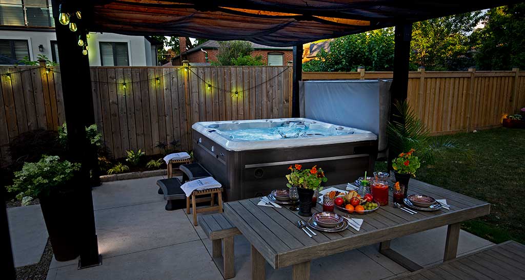 Spa dans un jardin posé sous un abris en début de soirée.