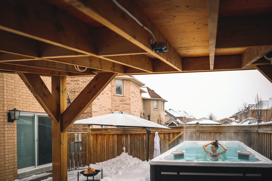 Un spa de nage est installé en extérieur, à proximité d'une maison. 