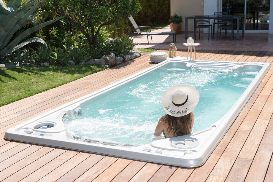 Une femme se détend dans une mini piscine (spa de nage)