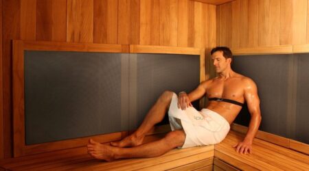 Un homme, bien installé dans un sauna infrarouge, bénéficie des bienfaits prodigués par l'équipement.