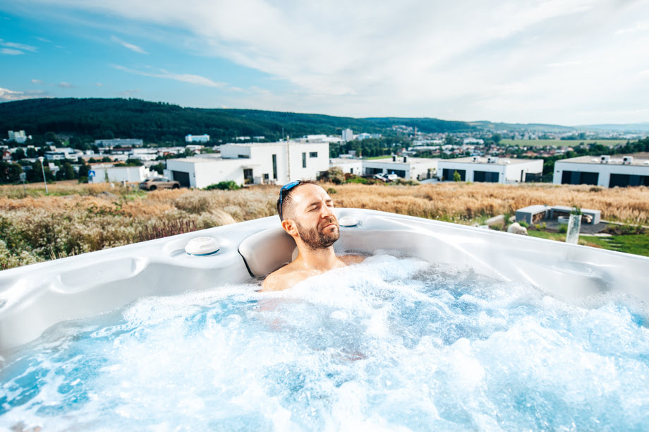 Un homme est installé dans un spa et profite des jets hydromassants qui procurent des massages relaxants et thérapeutiques.