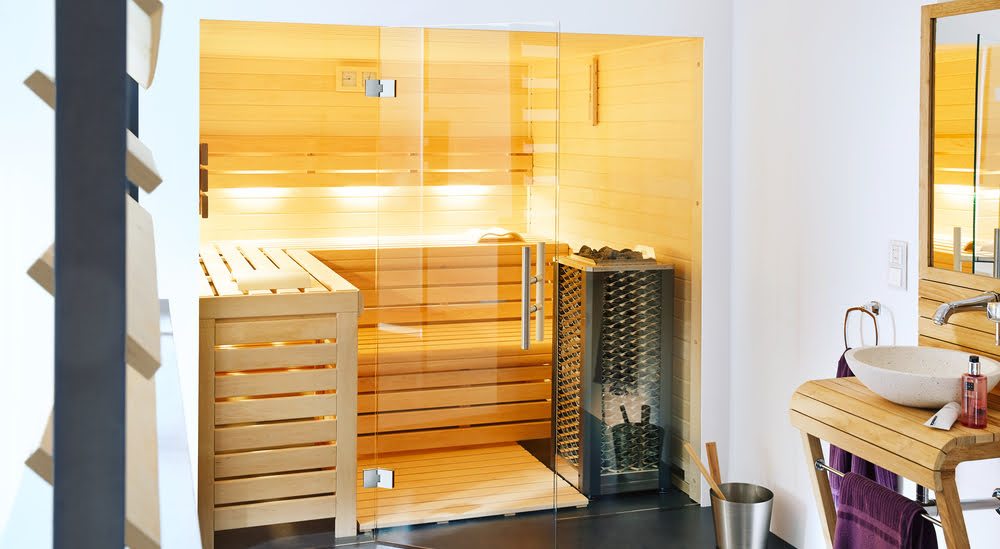 Sauna-finlandais Un sauna finlandais en bois avec une grande baie vitrée est installé dans une salle de bain.