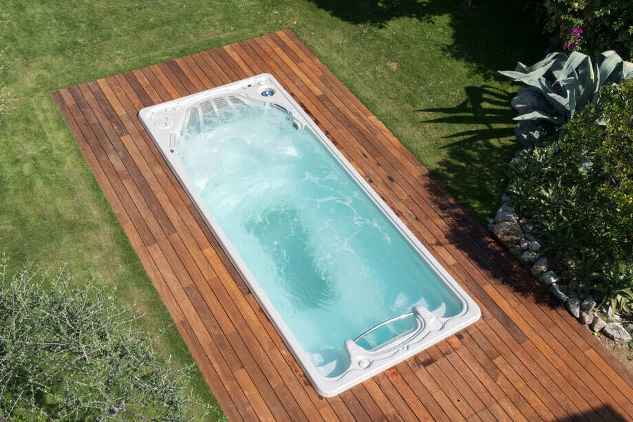 Une mini piscine (spa de nage) encastrée dans une terrasse