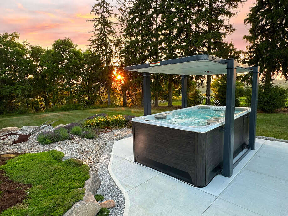 Photo d'une mini piscine hors-sol (spa de nage) installé dans un jardin avec un coucher de soleil
