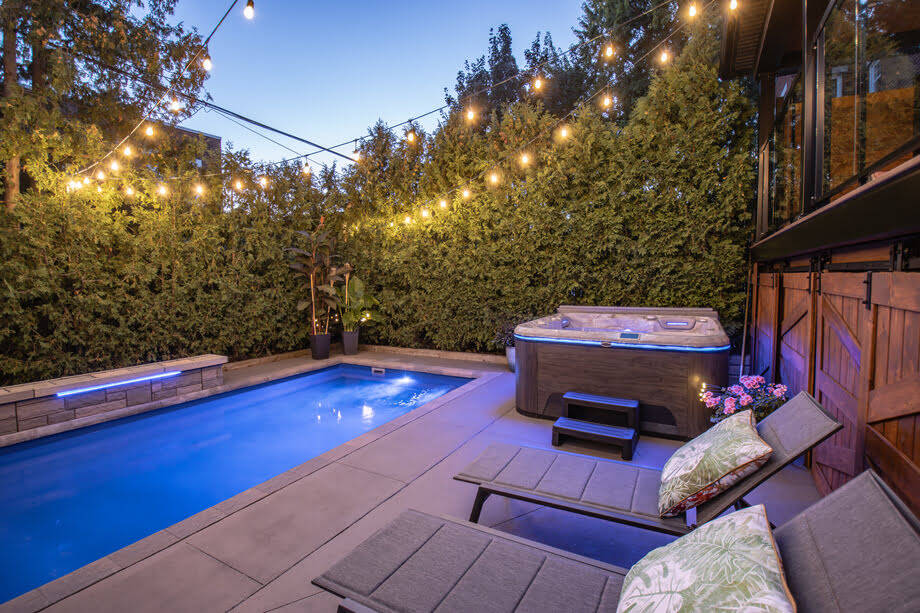 Un spa installé sur une terrasse, près d'une piscine. 