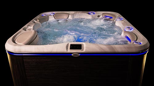 Un couple se détend dans un spa portable installé en extérieur.